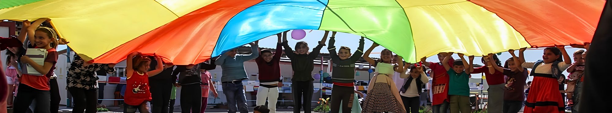 Enfants jouant sous un parachute multicolore lors d'une intervention