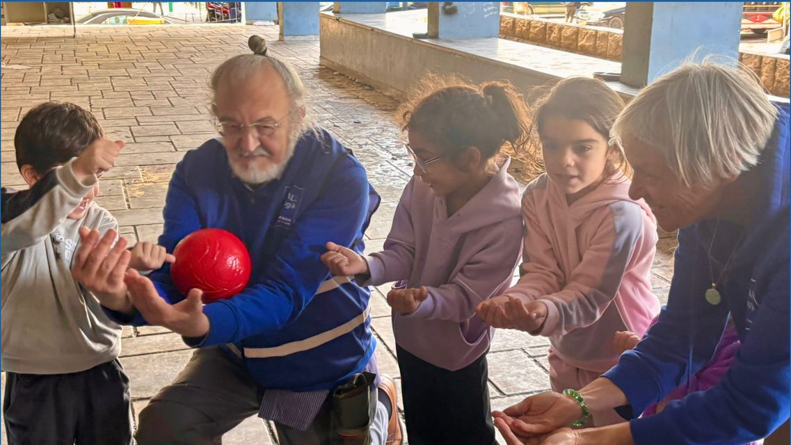 Séance de pédagogie d'urgence : un intervenant et des enfants autour d'un jeu de balle